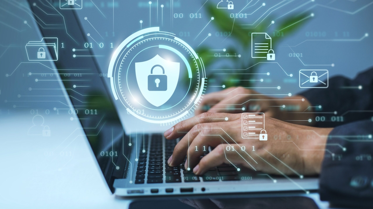 A businessman works on his laptop at home with a virtual display showing a symbol to signify cyber security privacy and online data protection